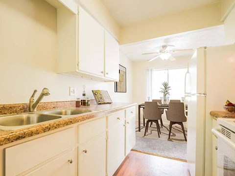 a kitchen with white cabinets and a dining room table