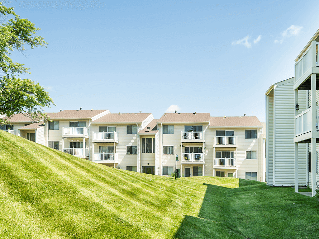 a row of apartment buildings on a grass covered hill