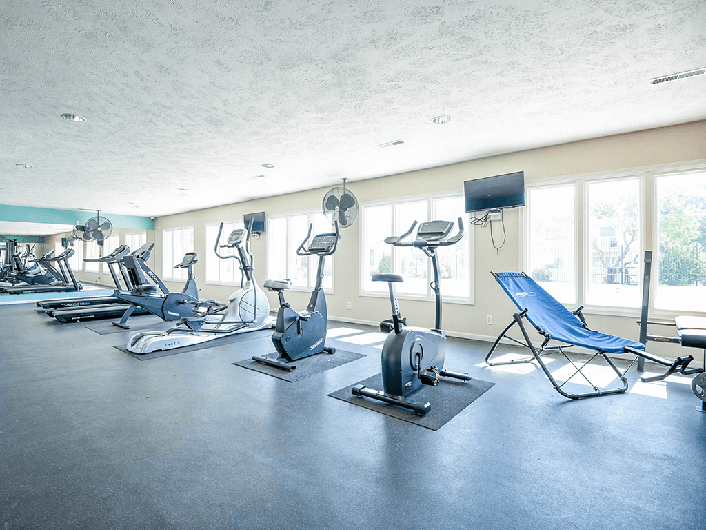 a gym with plenty of exercise equipment and windows