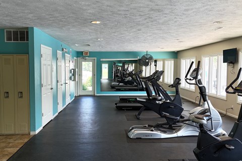A gym with exercise equipment and a blue wall.