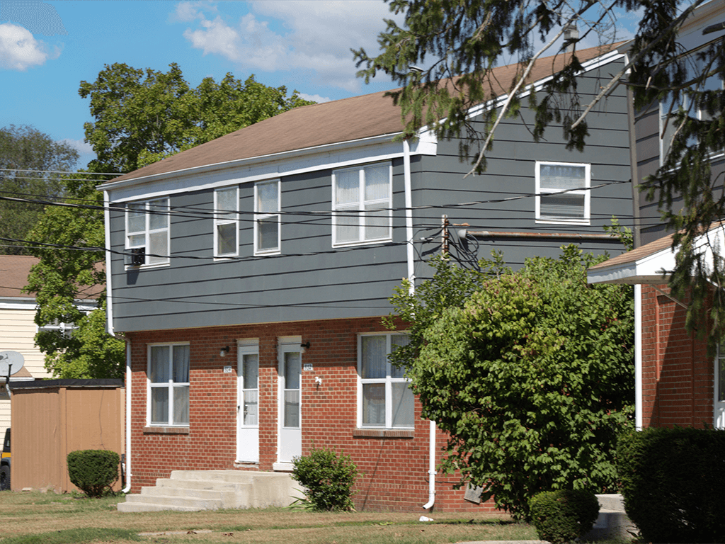 A grey house with a white door and windows.