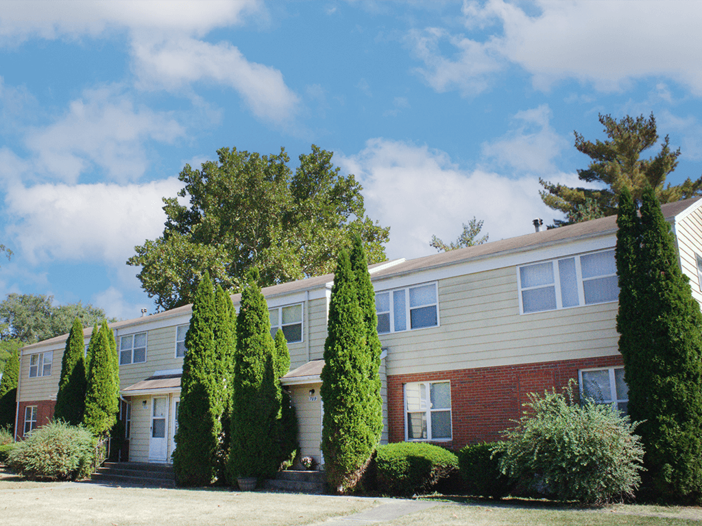 A row of houses with trees in front.