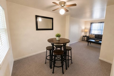 A small dining room with a round table and four chairs.