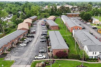 A parking lot with cars and a building in the background.