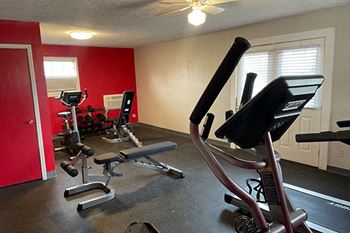 the fitness room has a lot of exercise equipment
