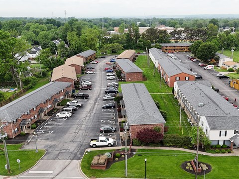 A parking lot in front of a building with a grassy area.