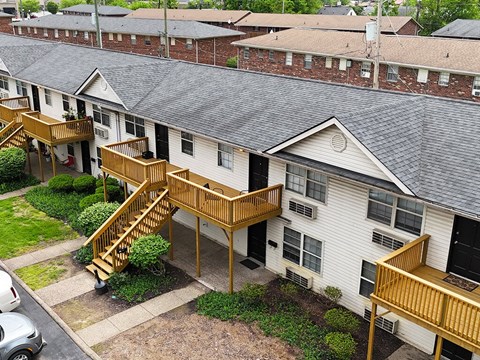 Apartment complex with a white building and a wooden deck.