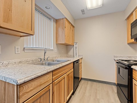 A kitchen with wooden cabinets and a granite countertop.