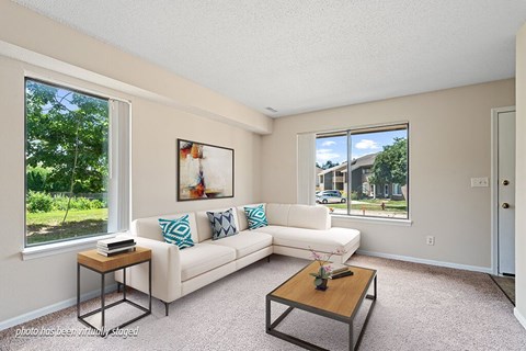 A living room with a white couch and a coffee table.