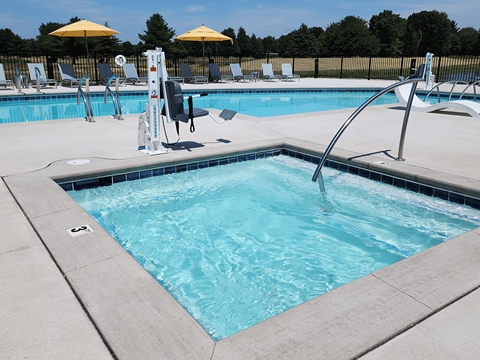 A pool with a diving board and sun loungers.