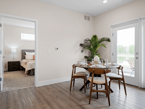 A dining room with a table set for four.