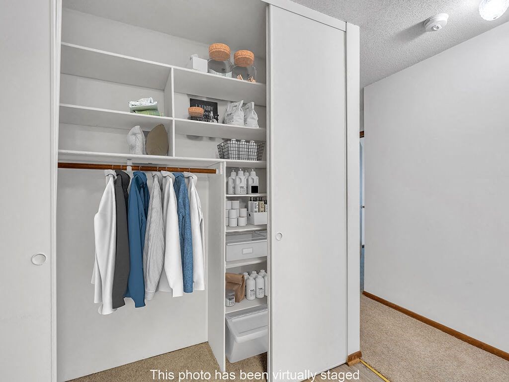 a walk in closet with shelves and clothes