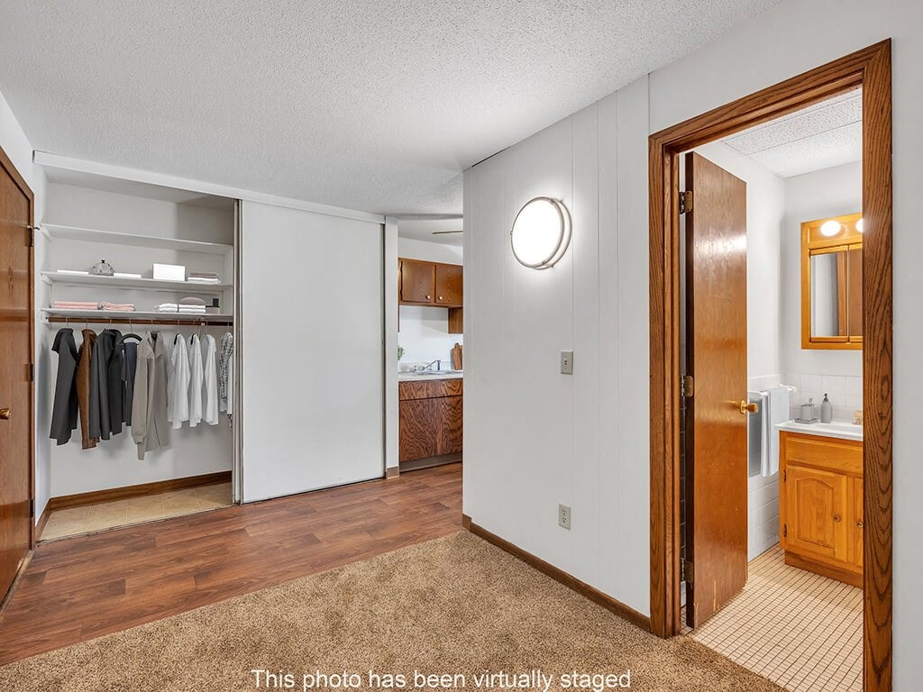 a bathroom with a mirror and a closet with clothes