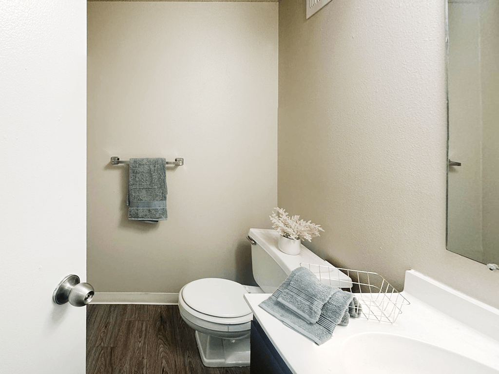 A white toilet sits next to a white sink in a bathroom.