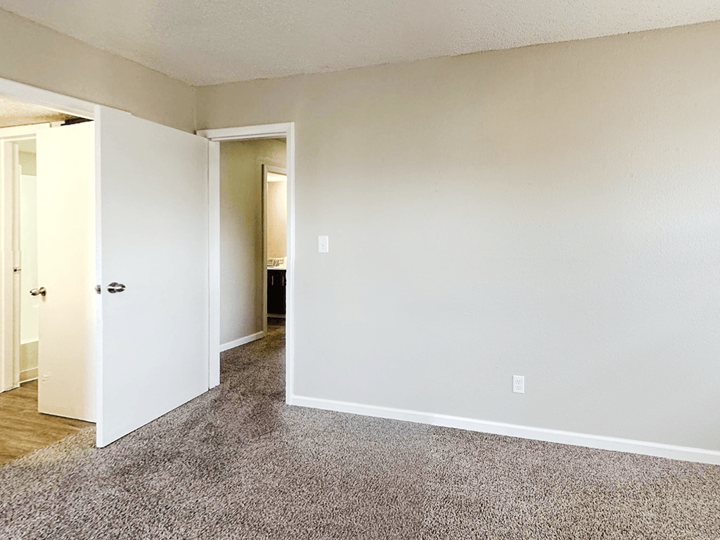 A room with a carpeted floor and white walls.