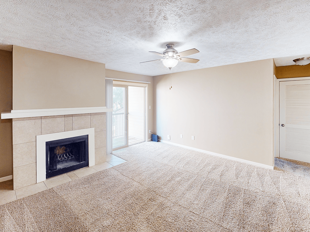A room with a fireplace and a ceiling fan.