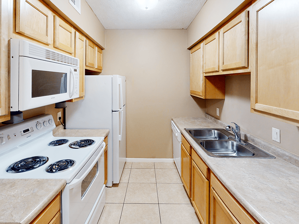 A kitchen with a white stove top oven and a white refrigerator.