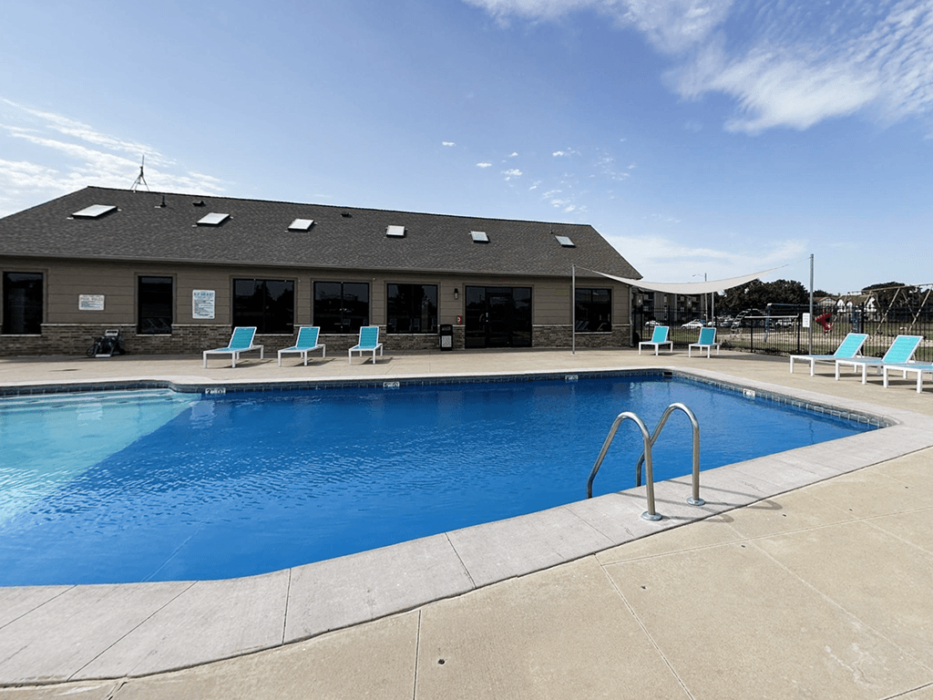 A large outdoor swimming pool with a building in the background.