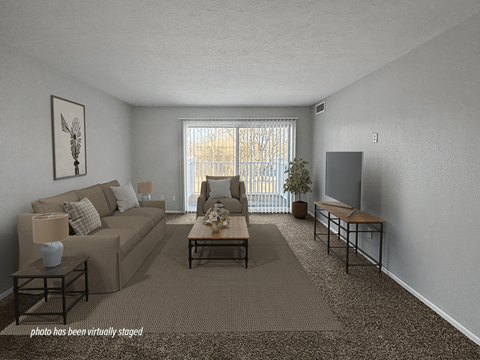 A living room with a couch, coffee table, and a painting on the wall.