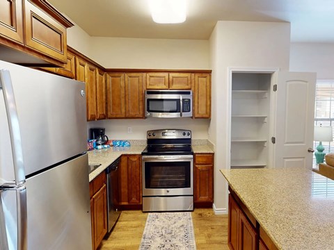 A kitchen with wooden cabinets and a stainless steel refrigerator.