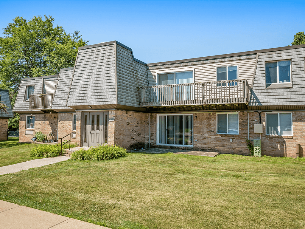 A brick building with a balcony and a sign that says