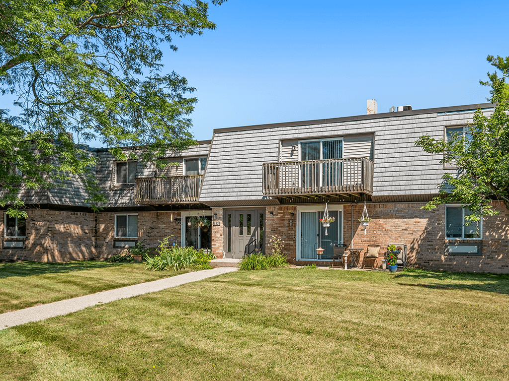 A house with a green lawn in front.