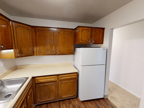 a kitchen with a white refrigerator and wooden cabinets