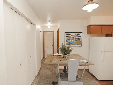 a kitchen with a dining table and a refrigerator