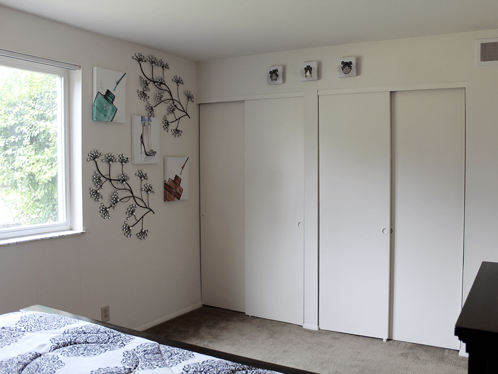 apartment bedroom with closets and a window