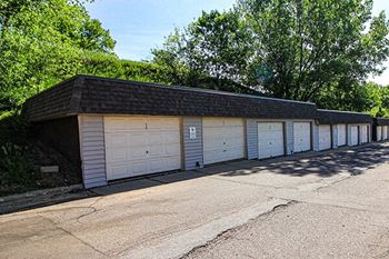 a row of garages with white doors and a black roof