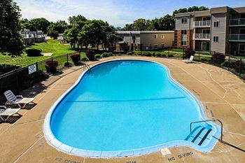 a large swimming pool with an apartment building in the background