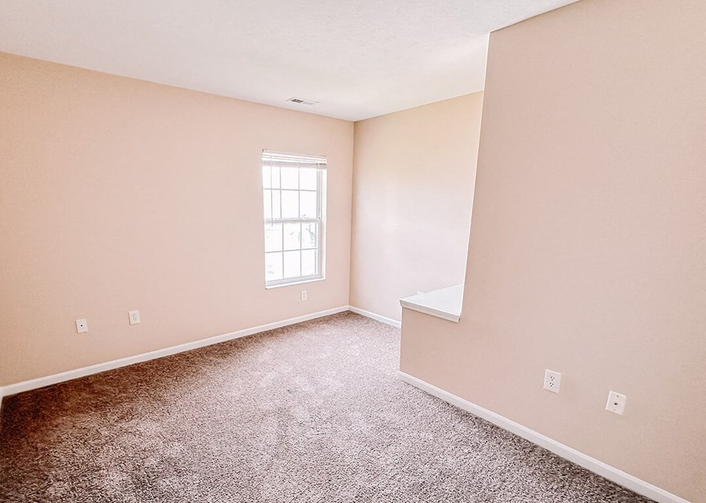 an empty room with carpet and a window