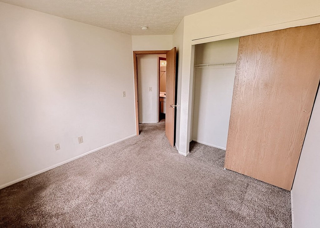 an empty living room with white walls and doors