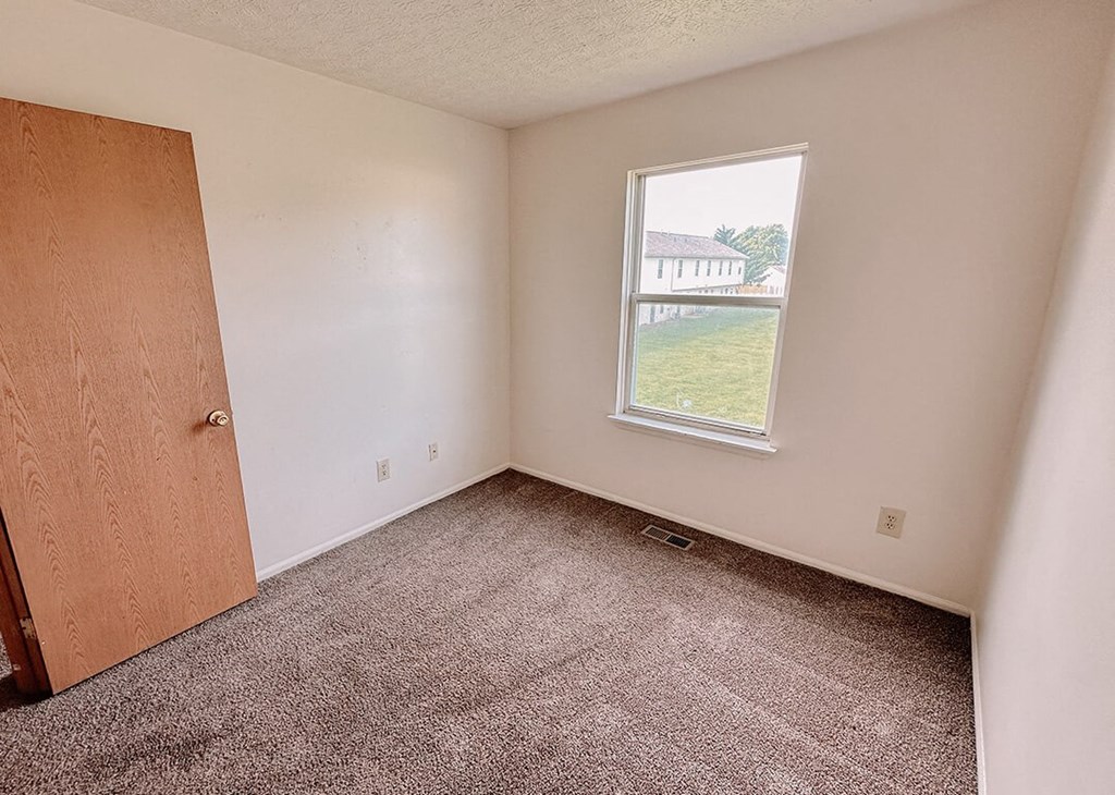 an empty room with a window and a door