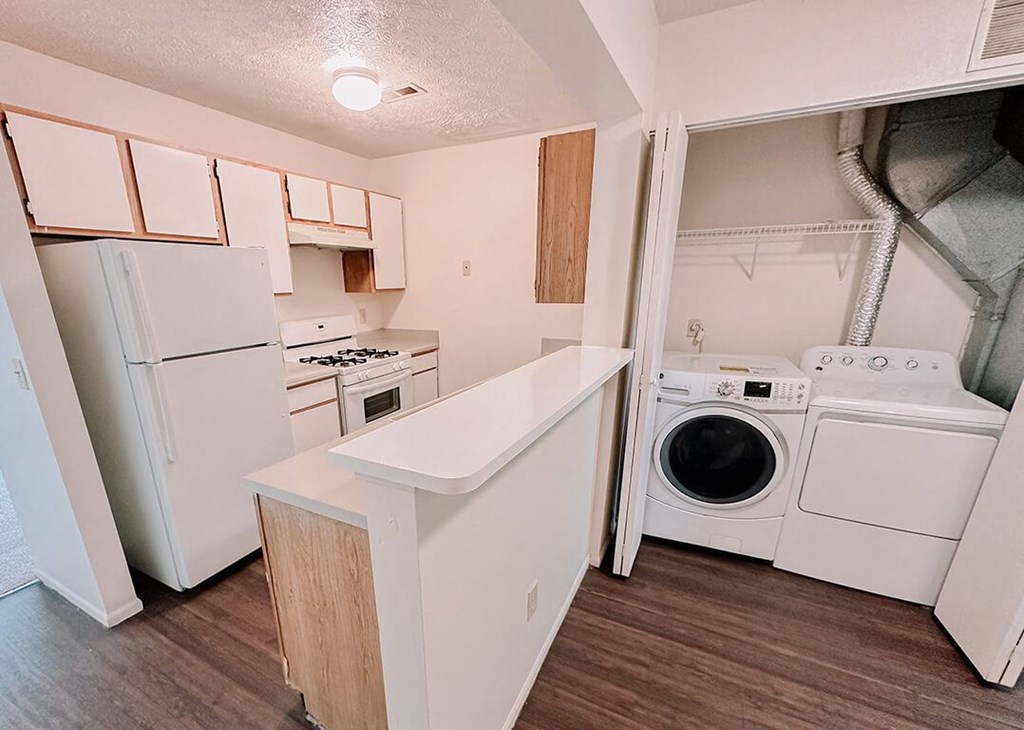 a kitchen with a washer and dryer and a refrigerator