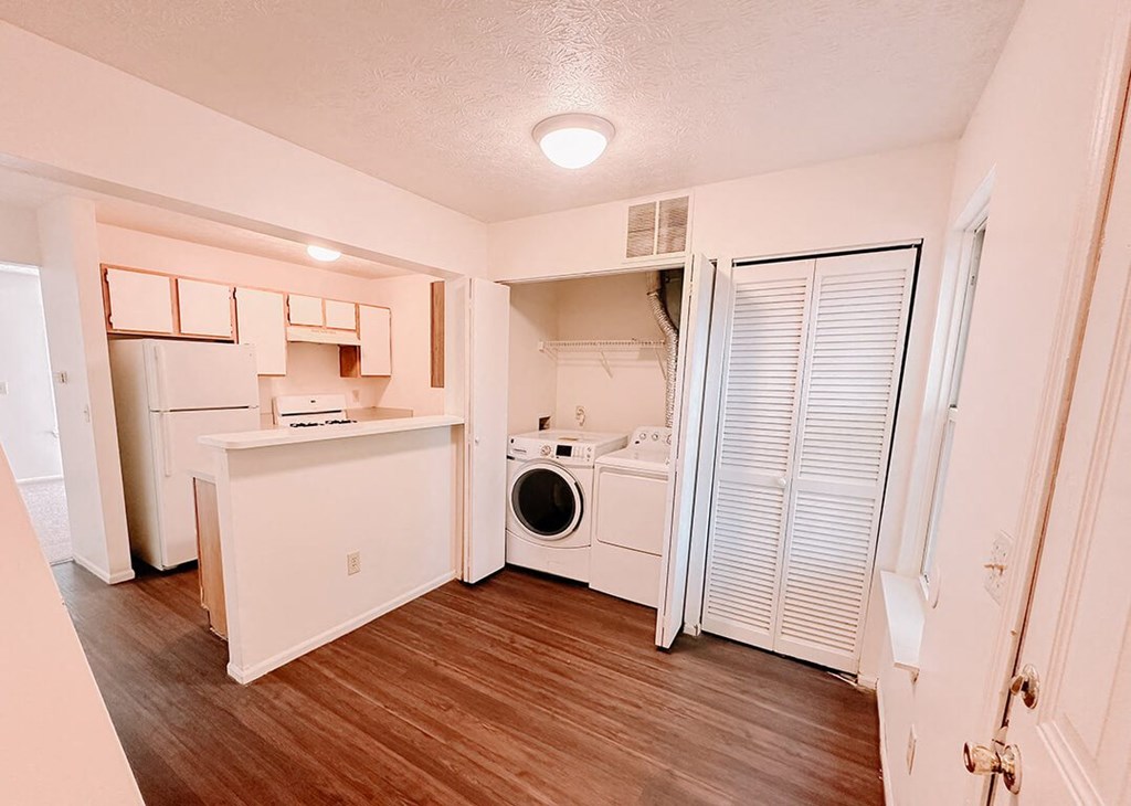 a white kitchen with a washer and dryer in it