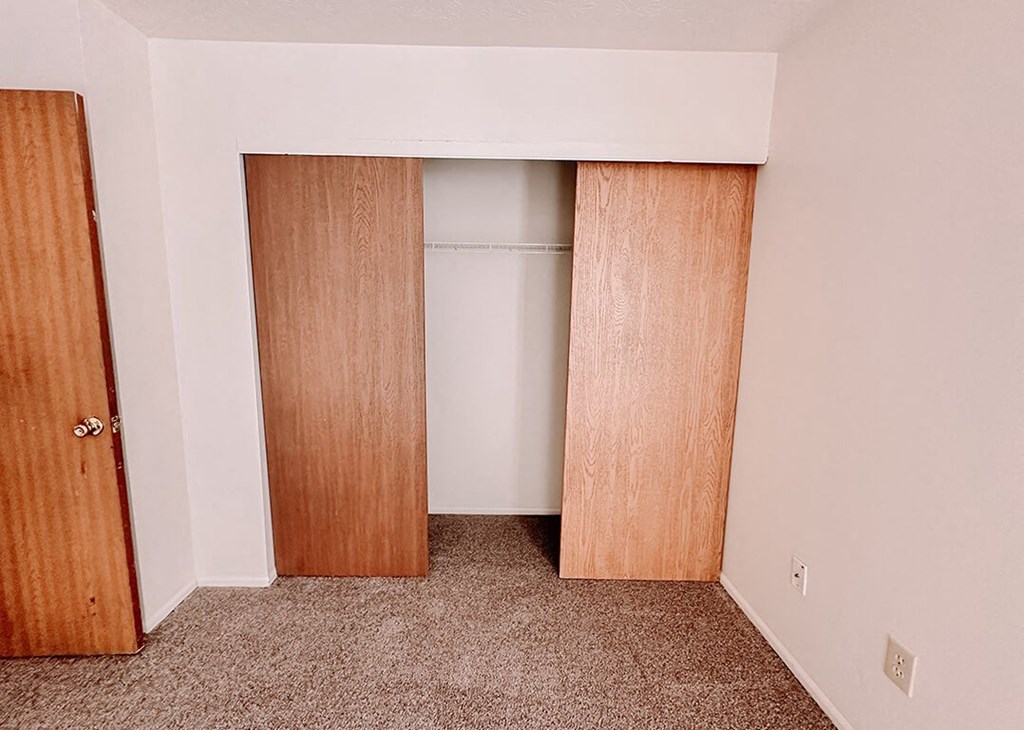 an empty closet in a room with wood doors