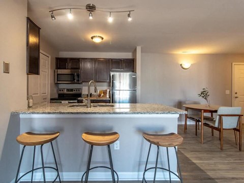 a kitchen with a counter and three bar stools