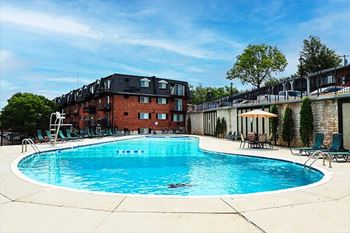A swimming pool in front of a red brick building.