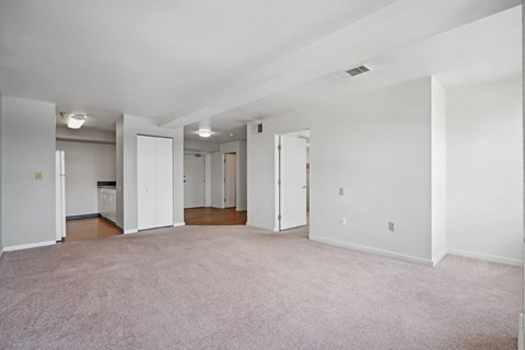 A large, empty room with carpeted floors and white walls.