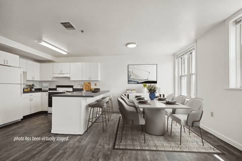 A white kitchen with a dining table and chairs.
