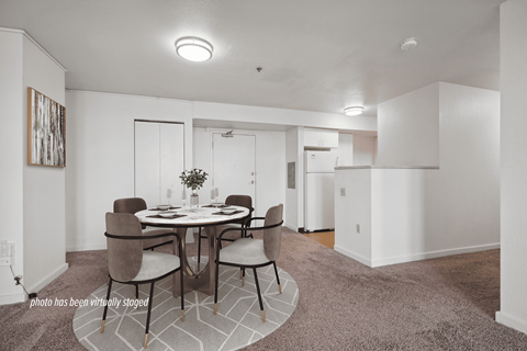 A dining room with a round table and chairs.