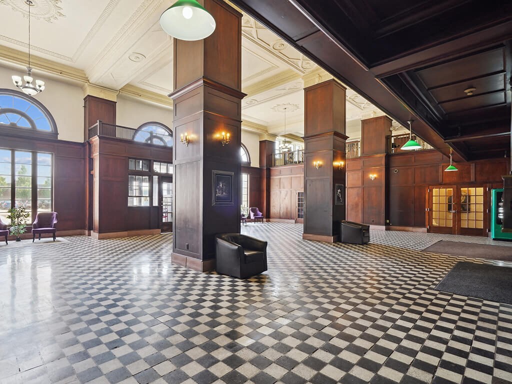 the lobby of a building with a checkered floor and columns