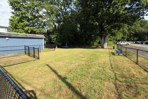 A backyard with a fence and a blue bench.