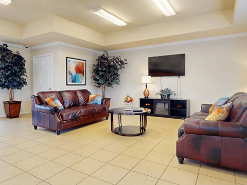 A living room with a brown leather couch and a coffee table.