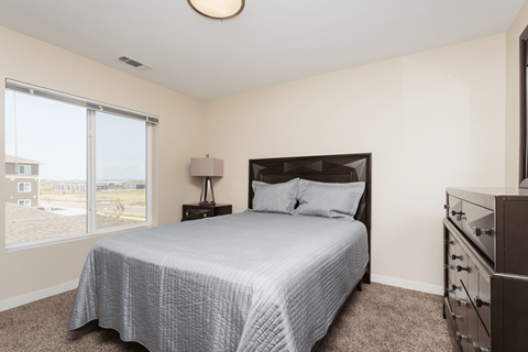 A bedroom with a large bed and a dresser.