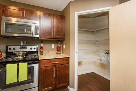 A kitchen with wooden cabinets and a stove top oven.