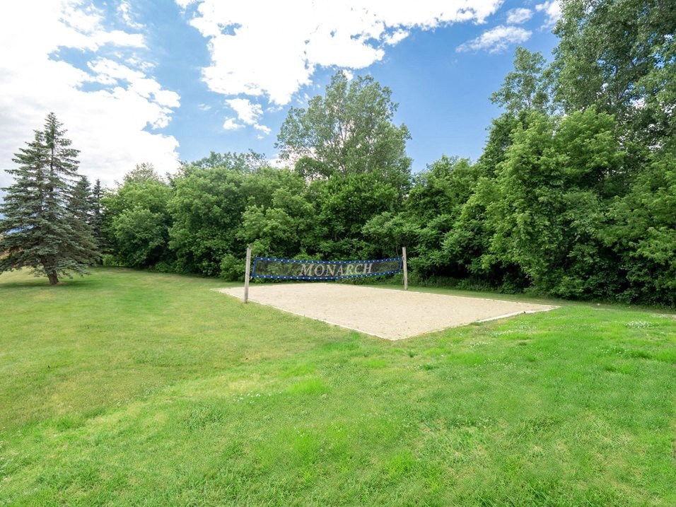 a volleyball court sits in the middle of a grassy field