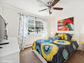 a bedroom with a bed and a ceiling fan