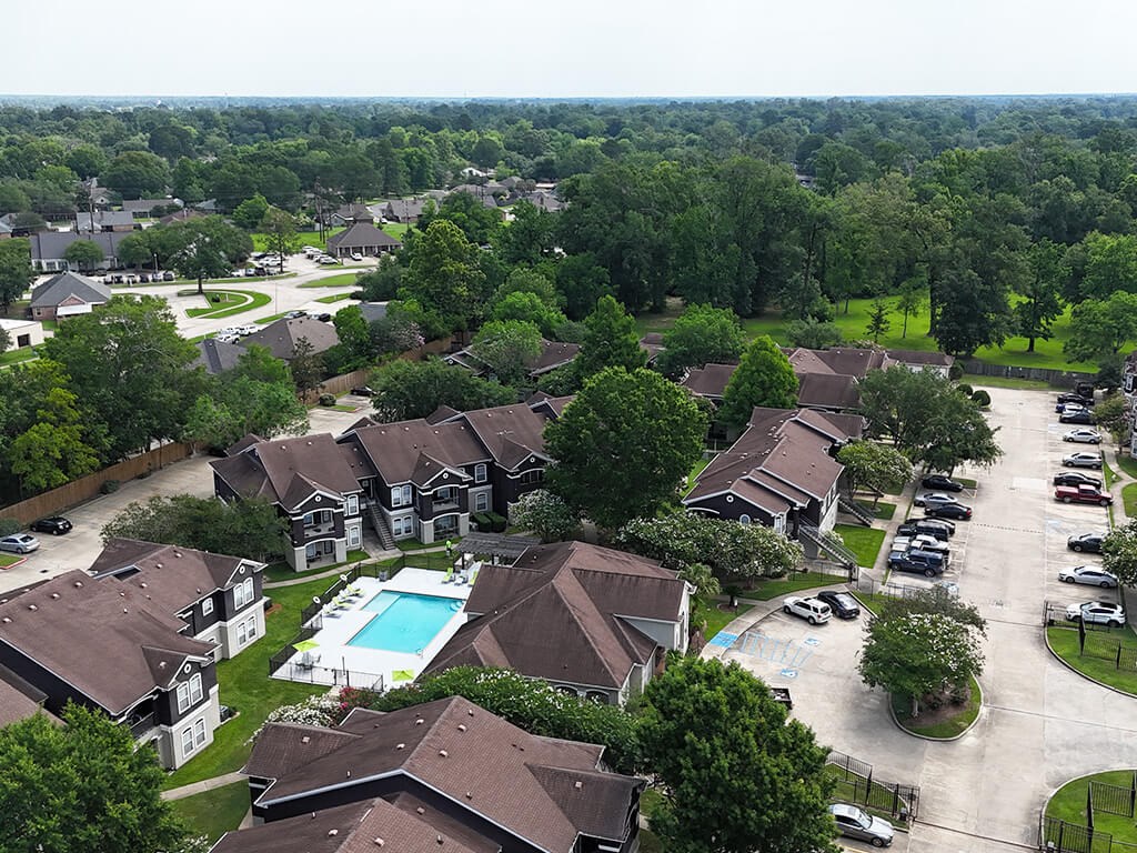 A bird's eye view of a residential area with houses and a swimming pool.